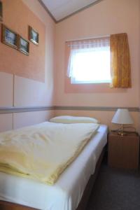 a bedroom with a white bed and a window at Holiday Home mit Pool by Interhome in Radewege