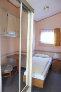 a bedroom with a bed and a desk and a window at Holiday Home mit Pool by Interhome in Radewege +2 photos