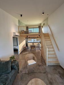 a living room with a staircase and a table at Lodges des Pontons - Cap Est - vue mer in Saint-Côme-de-Fresné