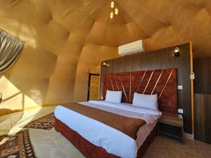 een slaapkamer met een groot bed in een kamer bij Wadi Rum Luxury Camp in Wadi Rum +7 foto's