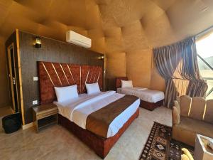 een slaapkamer met 2 bedden en een stoel in een kamer bij Wadi Rum Luxury Camp in Wadi Rum
