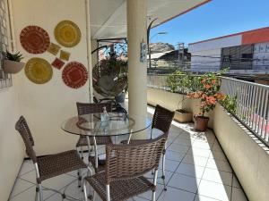 ein Balkon mit einem Glastisch und Stühlen in der Unterkunft Hotel Monólitos in Quixadá