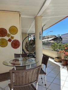 a patio with a glass table and chairs on a balcony at Hotel Monólitos in Quixadá