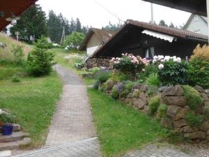 a garden with a brick path and a stone wall at Holiday Home Elfi by Interhome in Eisenbach +21 photos