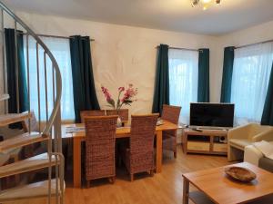 a living room with a table with chairs and a television at Apartment Daun by Interhome in Daun