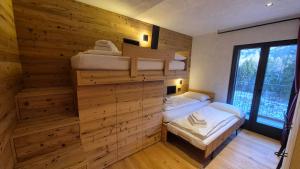 een slaapkamer met 2 stapelbedden in een houten muur bij La Trementina Apartment & Spa in Dimaro