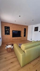 een woonkamer met een bank en een flatscreen-tv bij La Trementina Apartment & Spa in Dimaro