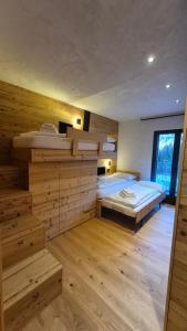 een slaapkamer met twee bedden en houten wanden bij La Trementina Apartment & Spa in Dimaro +15 foto's