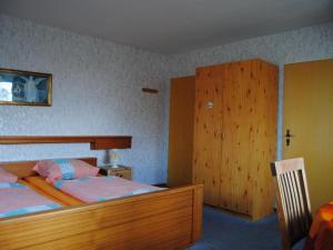 a bedroom with two beds and a wooden cabinet at Apartment Schule 5 by Interhome in Windeby