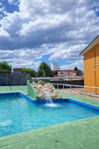 een zwembad met een glijbaan in een gebouw bij KIN Hotel in Villa Carlos Paz