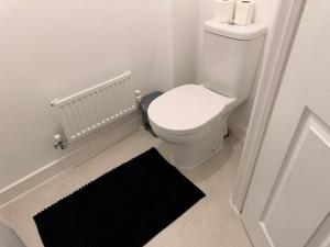 a bathroom with a white toilet and a black rug at Kennard Haven in Weldon +8 photos