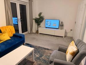 a living room with a blue couch and a tv at Kennard Haven in Weldon