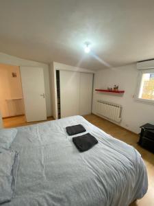 een slaapkamer met een groot bed met twee handdoeken erop bij Le Glatigny in Le Havre