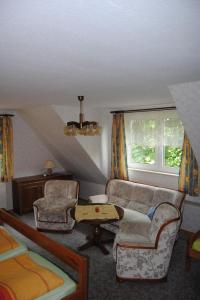 a attic living room with a couch and a chair at Apartment Schule 6 by Interhome in Goosefeld