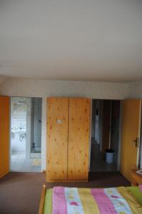 a bedroom with a bed with wooden cabinets and a bathroom at Apartment Schule 8 by Interhome in Windeby