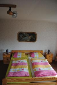 a bed with two pillows and a picture on the wall at Apartment Schule 8 by Interhome in Windeby
