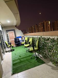 un ufficio con sedie verdi e un tappeto verde di Cozy Room Rashdiya 1 Ajman ad Ajman Altre 5 foto