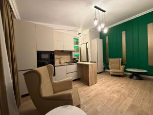 una cucina con pareti verdi e tavolo e sedie di Cozy Flat Stejari a Suceava