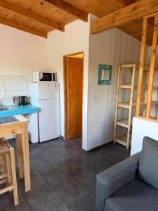 eine Küche und ein Wohnzimmer mit Kühlschrank und Tisch in der Unterkunft Freedom in Miramar
