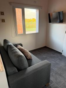 ein graues Sofa im Wohnzimmer mit Fenster in der Unterkunft Freedom in Miramar