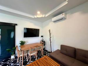 a living room with a table and a couch at Wanderlust Cove in Wok Tum