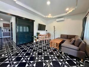 a living room with a couch and a table at Wanderlust Cove in Wok Tum +5 photos