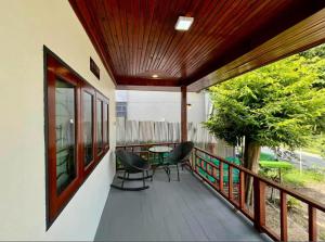 a porch with chairs and a table on a balcony at Wanderlust Cove in Wok Tum +3 photos