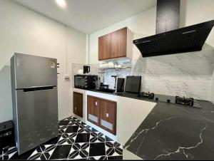 a kitchen with a black and white tile floor at Wanderlust Cove in Wok Tum