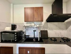 a kitchen with a microwave and a stove top oven at Wanderlust Cove in Wok Tum