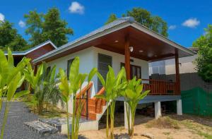 a house with a porch with a roof at Wanderlust Cove in Wok Tum