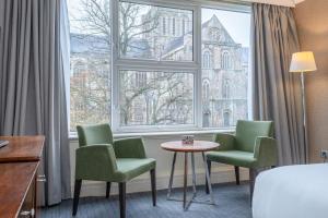 a hotel room with chairs and a table and a window at Winchester Wessex Hotel by Sunday in Winchester