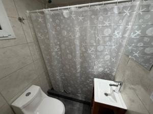 ein Bad mit einem Duschvorhang und einem WC in der Unterkunft Freedom in Miramar