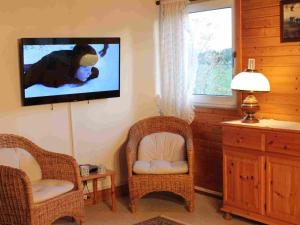 a living room with two chairs and a flat screen tv at Holiday Home Barbara by Interhome in Kittlitz