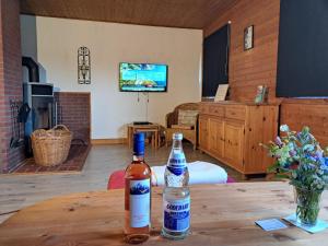 two bottles of alcohol sitting on a wooden table in a room at Holiday Home Barbara by Interhome in Kittlitz