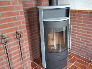 a brick wall with a wood burning stove with aperature at Holiday Home Barbara by Interhome in Kittlitz
