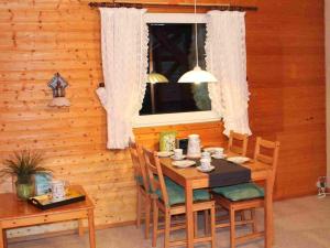 a wooden dining room table with chairs and a window at Holiday Home Barbara by Interhome in Kittlitz