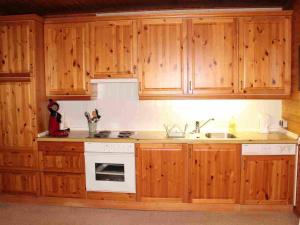 a kitchen with wooden cabinets and a white stove top oven at Holiday Home Barbara by Interhome in Kittlitz +11 photos