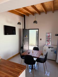 een eetkamer met een houten tafel en zwarte stoelen bij El Cerrito in Las Heras