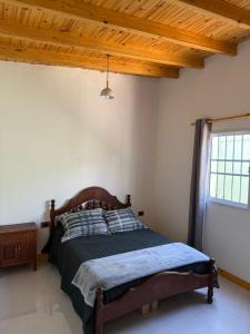 een slaapkamer met een bed en een houten plafond bij El Cerrito in Las Heras +3 foto's