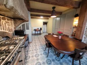 een keuken met een houten tafel en een fornuis bij Maison d'hôtes Coeurdacier in Monthureux-sur-Saône