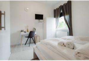 una camera da letto bianca con un letto e una scrivania di Rhein Lahn Hotel a Lahnstein