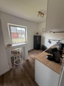 a kitchen with a counter and a table and a window at Huus Christine in Holtgast