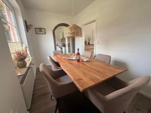 a dining room with a wooden table and chairs at Huus Christine in Holtgast +17 photos
