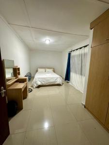 een slaapkamer met een bed en een grote tegelvloer bij The 12th Avenue in Lusaka