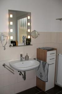 a bathroom with a sink and a mirror at Apartment Fewo Edison by Interhome in Holzdorf +19 photos