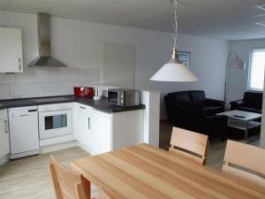 a kitchen and living room with a table and a kitchen and a dining room at Apartment Fewo Edison by Interhome in Holzdorf