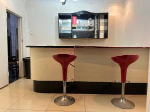 twee rode krukken aan een toonbank in een restaurant bij The 12th Avenue in Lusaka +9 foto's