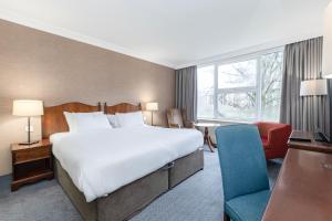 a hotel room with a large bed and a chair at Winchester Wessex Hotel by Sunday in Winchester +114 photos