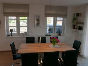a dining room table with chairs and flowers on it at Holiday Home Knut by Interhome in Mellnitz +25 photos