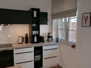 a kitchen with black and white counters and a window at Holiday Home Knut by Interhome in Mellnitz